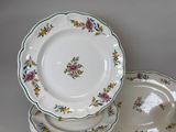 a stack of plates with flowers on them sitting on a table