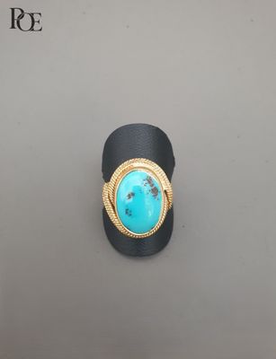 un gros plan d'une bague sertie d'une pierre de turquoise