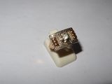 an image of a gold ring with a diamond on top of a white surface