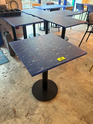 des tables et des chaises dans une pièce où se trouve une affiche posée sur la table