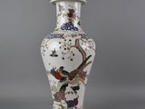un vase blanc orné d'un oiseau et de fleurs