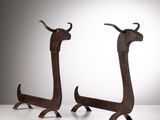 deux sculptures métalliques représentant des bovins à longues cornes, posées sur une surface blanche avec un fond gris