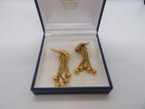 une paire de boucles d'oreilles en or dans un coffret bleu