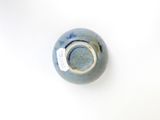 a blue vase with a tag on it sitting on a white surface