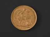 a close up of a gold coin on a black surface