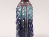 a blue and purple vase sitting on a white surface