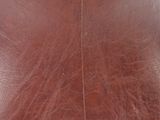 a close up of a brown leather bag on a white surface