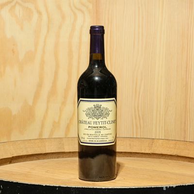 a bottle of wine sitting on top of a barrel