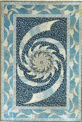 a blue and white quilt with a spiral design on it