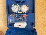 someone standing next to a blue box with gauges and a bottle of water in it