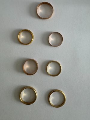 several different types of rings are arranged on a white surface