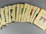 six livres sont empilés les uns sur les autres sur une surface grise