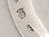 a silver plate with a spoon on it on a table