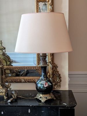 a black table with a lamp on it and a mirror in the background