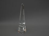 un obélisque en verre transparent sur fond noir