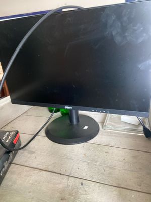 a computer monitor sitting on top of a wooden table