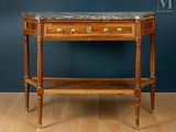 une vieille table en bois avec un plateau en marbre, posée sur un parquet en bois massif
