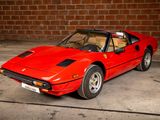 a red sports car parked in front of a brick wall