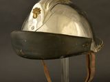an old helmet on a stand against a black background