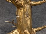 a glass table with a gold tree on top of it