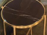 a black and gold side table with a black marble top