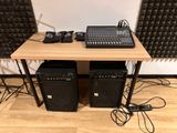 two speakers and a mixer on a table in a room