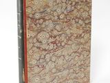 an old book with a brown cover and a red binding