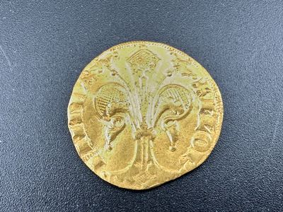 gros plan d'une pièce d'or sur une surface noire