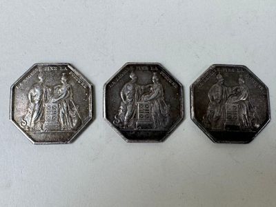 Trois types différents de pièces d'argent sont représentés sur un fond blanc