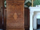 une grande armoire placée dans un coin d'une pièce dotée d'une cheminée
