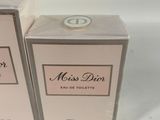 two boxes of perfume sitting next to each other on a white surface