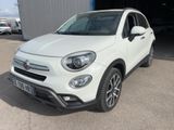 the white fiat suv is parked in front of a garage