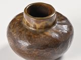 a small brown vase sitting on a white surface