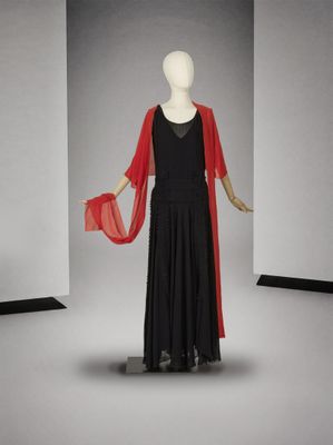 un mannequin vêtu d'une robe noire et d'une cape rouge