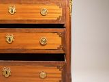 a small wooden chest of drawers with marble top
