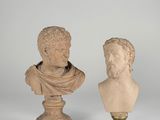 a pair of marble busts of men on pedestals