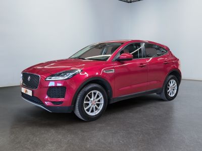 a red jaguar suv parked in a showroom