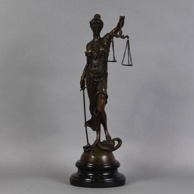 bronze statue of a lady holding a balance scale and a sword