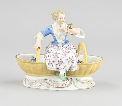 porcelain figurine of a woman sitting in a basket with flowers