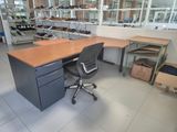a desk and chair in a room with a lot of shoes on the shelves