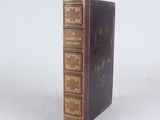 an old book sitting on top of a table next to a white wall