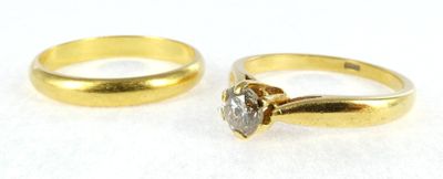 two gold wedding rings with a diamond on top of them