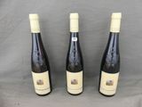 three bottles of wine sitting on a table next to each other
