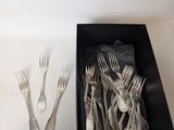 a box of forks and spoons sitting on a table