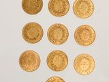 several gold coins are arranged in a triangle on a white surface
