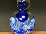 a blue glass bottle sitting on top of a wooden table