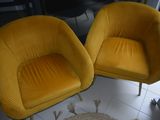 pair of yellow chairs in a living room with a rug on the floor