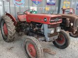 un tracteur rouge garé devant un bâtiment
