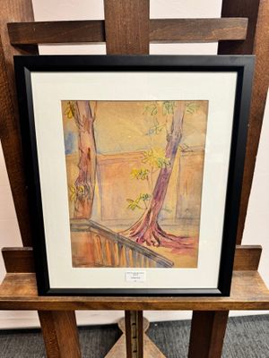 tableau représentant un arbre, encadré et posé sur un support devant un mur