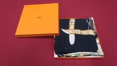 an orange box with a knife inside of it on a red surface